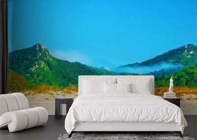 two mountains, overgrown with trees, covered with mist. Wall mural