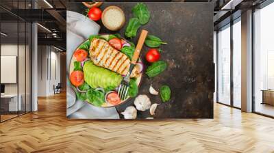 Grilled chicken breast and fresh vegetable salad with spinach leaves, avocado and tomatoes on a dark background. Salad of greens with meat. Ketogen diet. Dietary nutrition. Copy space.  Wall mural