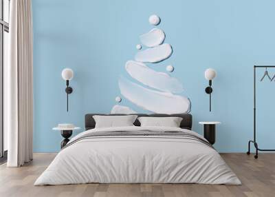 The concept of a Christmas tree in the form of cosmetic touches on a blue background. Moisturizing the skin in winter. Winter concept. Wall mural