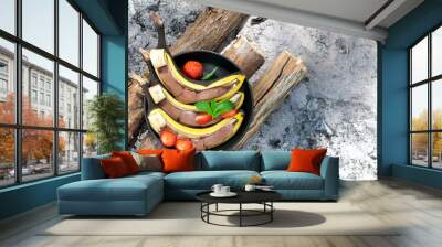 Grilled sweet bananas with chocolate and strawberries cooked on charcoal. Wall mural