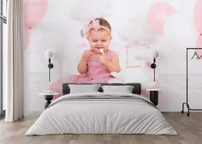 cute little child girl eating birthday cake and celebrating her first birthday Wall mural