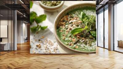 A plantbased recipe of green soup topped with nuts and seeds Wall mural