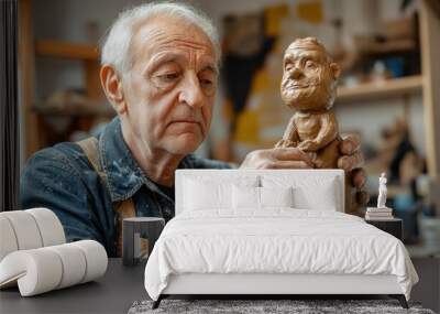 An elderly man is currently engaged in the art of creating a clay sculpture that depicts a man Wall mural