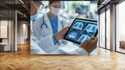 Medical team analyzing chest x-rays on a digital tablet in a hospital Wall mural