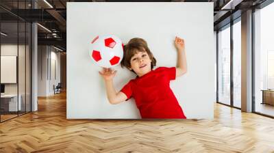 portrait of a little boy lying with a soccer ball on a white background with space for text Wall mural