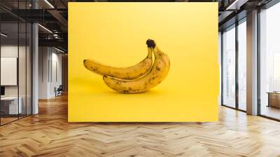 Rotten bananas on a yellow background with copy space Wall mural