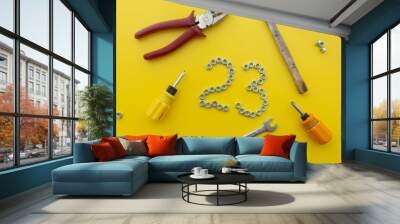 The number 23 of nuts with different tools on a yellow background. Defender of the Fatherland Day Wall mural