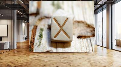 Wooden rune Gebo close-up on a wooden background. Soft focus Wall mural