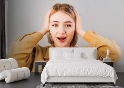 Surprised happy beautiful woman looking at camera in excitement. Isolated on gray background Wall mural