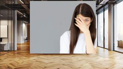 Young woman with hand on her face isolated on gray background, facepalm Wall mural