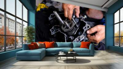 A motorcycle mechanic is working on the engine gear. Wall mural