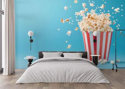 Freshly popped popcorn spilling from a striped container Wall mural