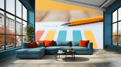 A colorful bar chart on paper with a pen, showcasing data analysis and reporting on a wooden table. Perfect for business themes. Wall mural