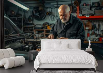 Old man Car engineer inspecting the engine of a vintage sports car with tools and equipment Wall mural