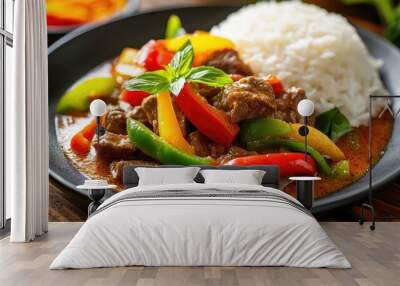 A plate of Thai Red Curry with tender beef and colorful bell peppers, served with a side of steamed rice, highlighting the rich and creamy texture of the curry. Wall mural