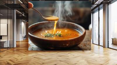 Hot soup being ladled into a bowl, steam swirling up from the rich broth, rustic wooden table Wall mural