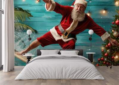 A cheerful Santa Claus in a red outfit surfs on a board against a festive backdrop with palm trees and Christmas decorations. Wall mural