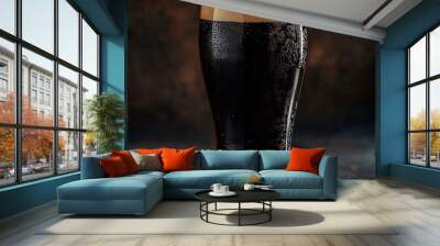 Tall glass full of dark beer over a dark background Wall mural