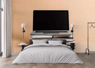 A notebook stacked on top of a laptop, suggesting a busy workday in progress. Wall mural