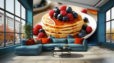 A plate of pancakes topped with fresh berries and syrup, with utensils neatly placed on the side. Wall mural