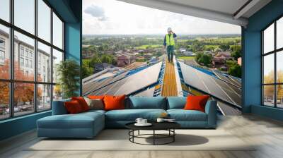 A male engineer working on a solar power plant checks the maintenance of solar panels on the roof. Wall mural