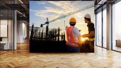 A team of construction engineers talks to managers and construction workers at the construction site. Quality inspection, work plan, home and industrial building design project Wall mural