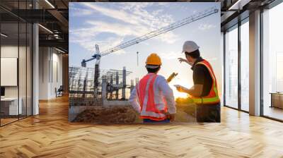 A team of construction engineers talks to managers and construction workers at the construction site. Quality inspection, work plan, home and industrial building design project Wall mural