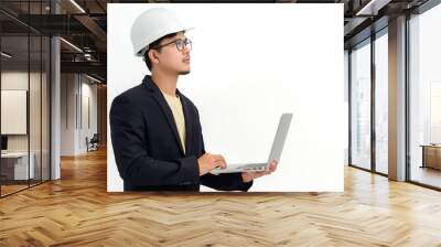 Asian male architect or engineer wearing white hard hat holding laptop isolated on white background Copy space over a white studio background. Wall mural