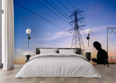 Silhouette of an electrical engineer flying a drone inspecting electricity at the station to see work Planned by producing power at the high voltage electrodes. Wall mural