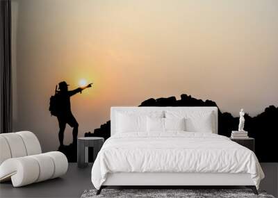 Silhouette of young male tourists Stand and watch the beautiful sunset on top of the mountain with your backpack. Wall mural