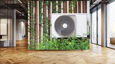 The air conditioner is mounted on the wall with the trees of the building with the garden in the front row. Wall mural