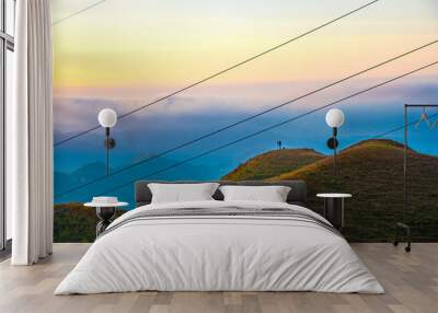 The photographer in the mountains of sunrise and sunset clouds background Wall mural