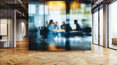 Business team collaborating around a table in a modern office, captured through glass walls, planning for success with a blurred effect that adds dynamic movement, emphasizing teamwork and strategy. Wall mural