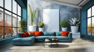 Minimalistic interior with white mockup canvas on wall, potted plants, concrete floor, gray-blue background, and soft sunlight effects. Wall mural