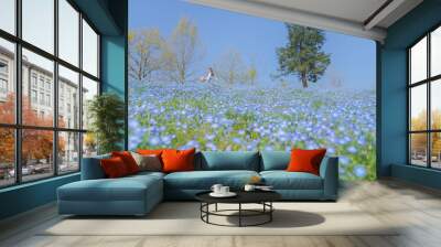 Girls and blue flowers on the hillside，sunny and happy life Wall mural