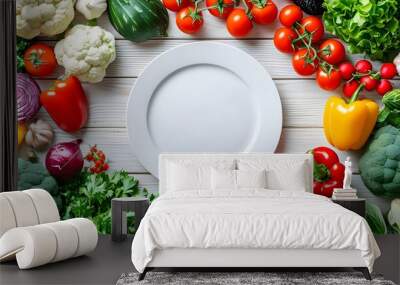 Colorful display of fresh vegetables and fruits arranged around a white plate on a light wooden surface Wall mural