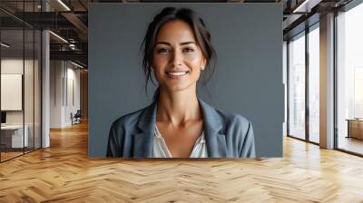 Confident woman exuding joy in casual attire against a sleek grey backdrop, embodying modern simplicity Wall mural