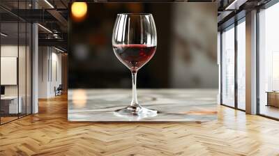 Elegant glass of red wine on polished marble countertop with a blurred background ambiance Wall mural