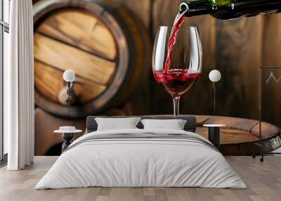 Rich red wine pouring from a bottle into a glass beside a rustic wooden barrel Wall mural