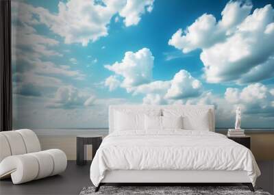 Serene sandy beach under a vibrant blue sky adorned with fluffy white clouds Wall mural