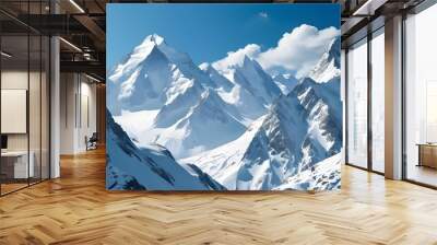 Serene winter landscape with majestic snow-covered mountain peaks beneath a clear blue sky Wall mural