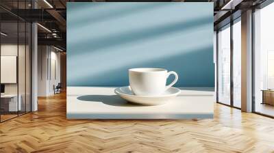 Warm sunlight illuminating a white coffee cup and saucer on a table, creating a cozy and inviting atmosphere. Wall mural