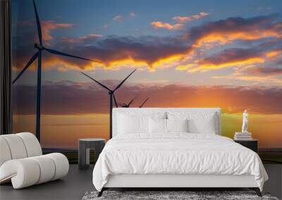 Wind turbines silhouetted against a stunning sunset, representing energy harnessing and progress in renewable power generation Wall mural