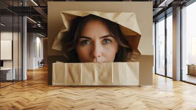 woman playfully concealing herself beneath an empty paper bag Wall mural