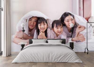 A family of four in bed in the bedroom Wall mural