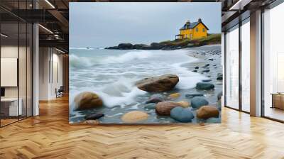 Stones and waves on the tranquil beach, and a yellow house in the distance Wall mural