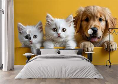 Adorable kittens and puppies peeking over an empty table with a cheerful yellow backdrop Wall mural