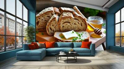 Artisan whole grain bread loaf with sliced pieces, butter and honey on a wooden board, decorated with fresh green herbs Wall mural