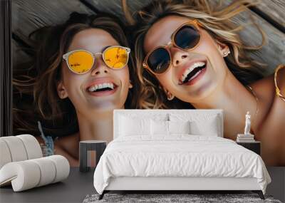 Cheerful summer vibes as best friends in sunglasses share laughter on a wooden floor Wall mural