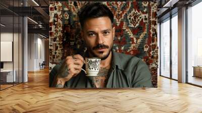 Cozy coffee experience featuring tattooed man enjoying latte art in a rustic setting with patterned rug and relaxed daytime ambiance Wall mural